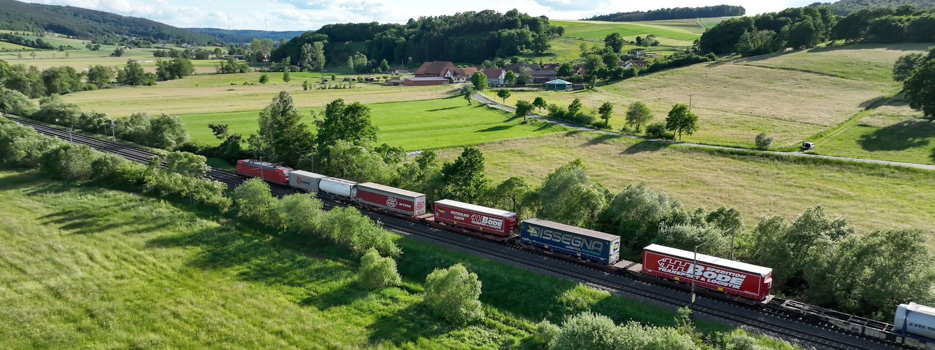 DB cargo train running through a lush green landscape